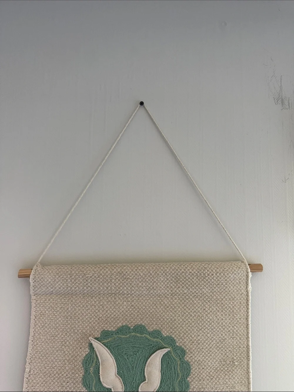 Handwoven Cream Wall Hanging with Green Triceratops Motif Nursery Design